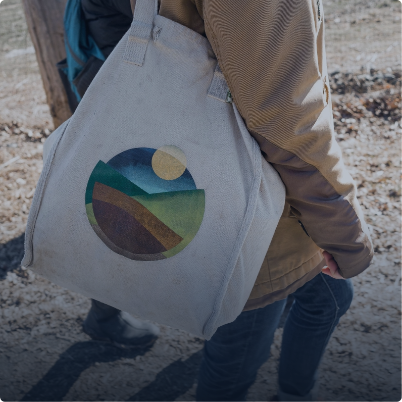 Woman carrying Hawthorne Valley logo tote bag.