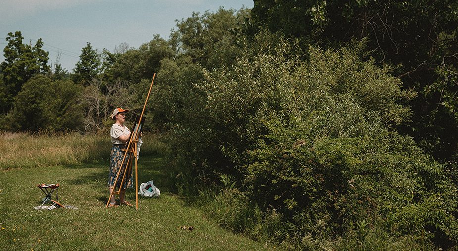 student outdoors at an easel.